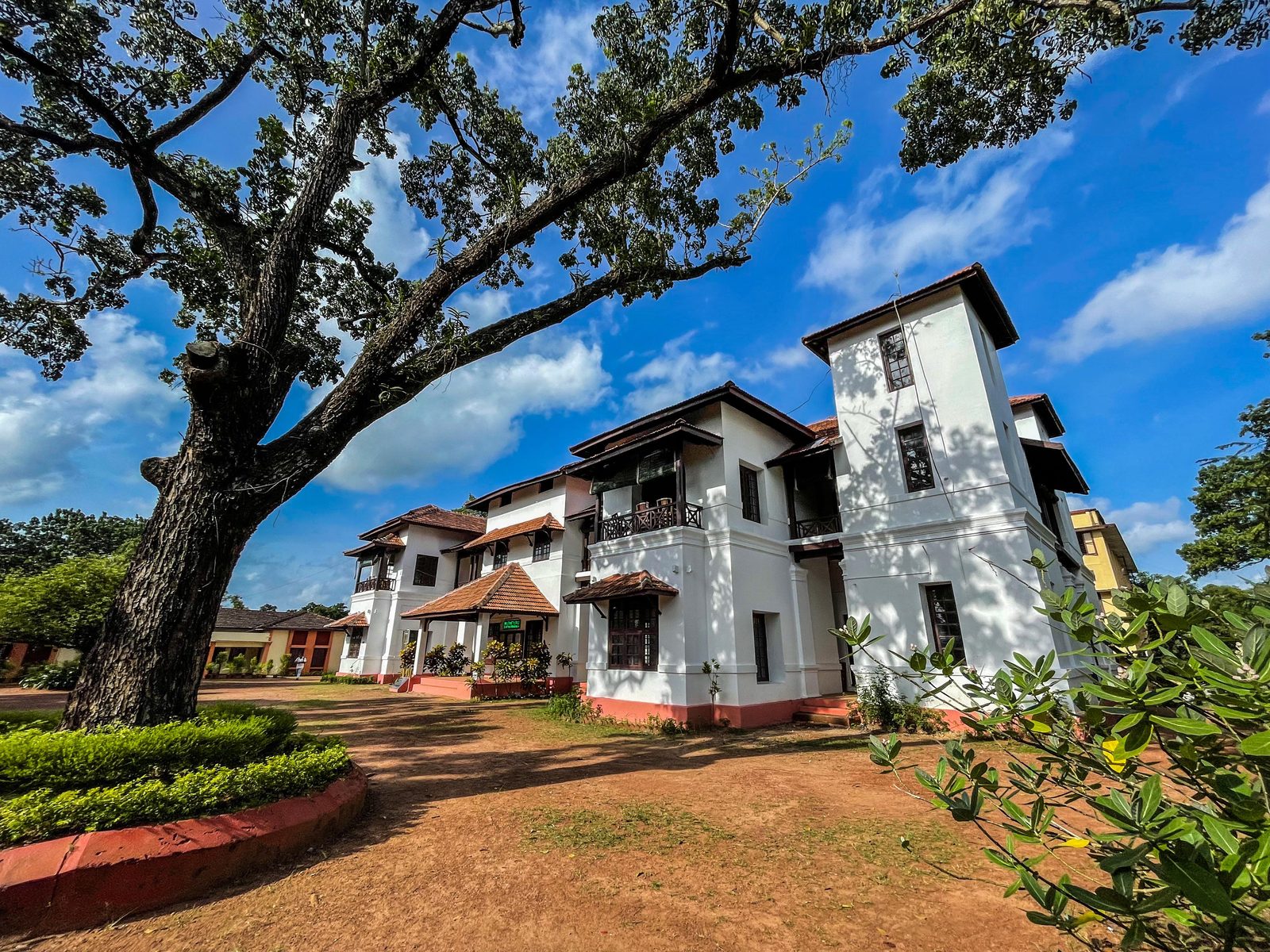 Heritage building of Union Christian College, Aluva, framed by trees